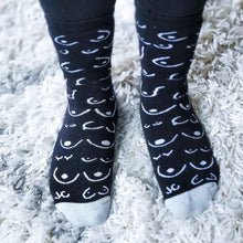 Load image into Gallery viewer, Black socks with white pattern worn on a white shag carpet