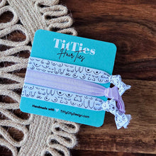 Load image into Gallery viewer, TiffTies hair ties on a branded card with decorative elements on a wooden surface