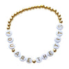 Bracelet with gold and white beads spelling out 'YOU ARE THE TITS' on a white background