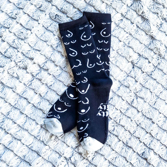 Black socks with white patterns on a textured white surface