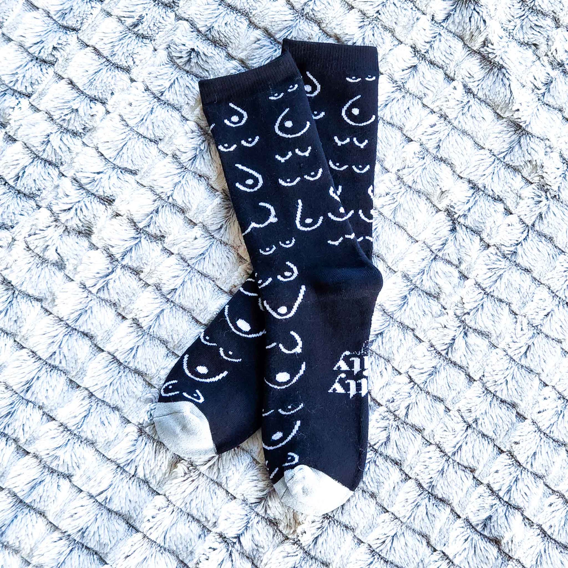 Black socks with white patterns on a textured white surface