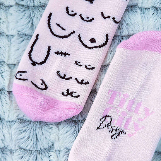 Pink socks with black designs on a textured surface