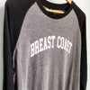 Breast Coast baseball t-shirt with gray body and black sleeves with slogan across the chest, close up, front view, on hanger