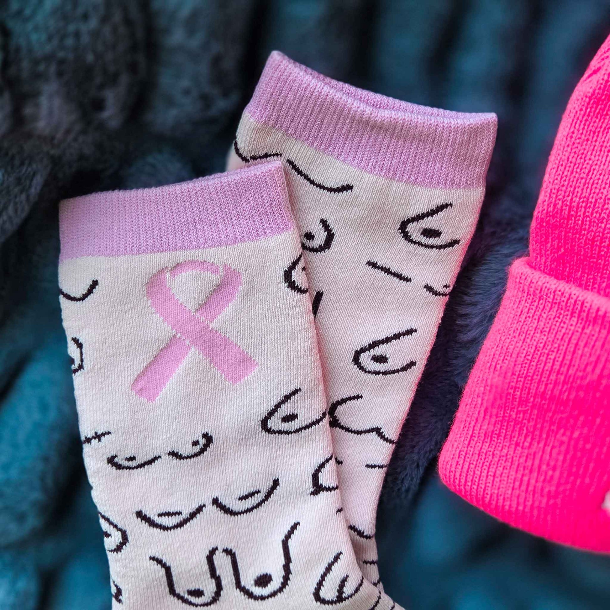 Pair of socks with pink ribbons and pink cuffs on a dark background