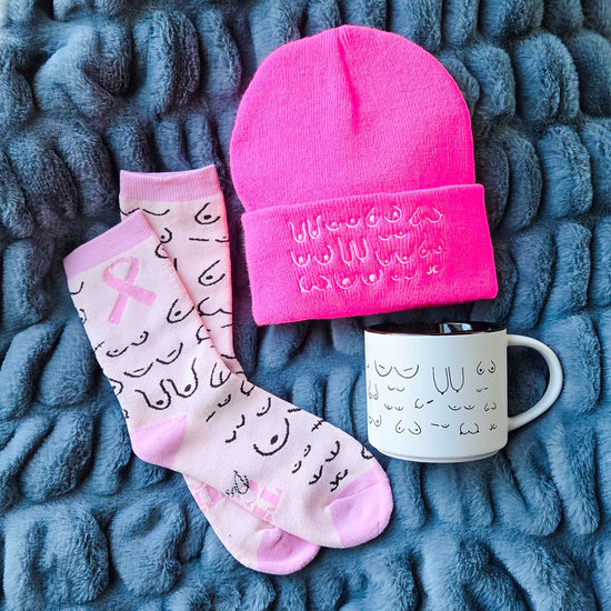 Pink beanie, socks, and mug with text on a textured blue surface