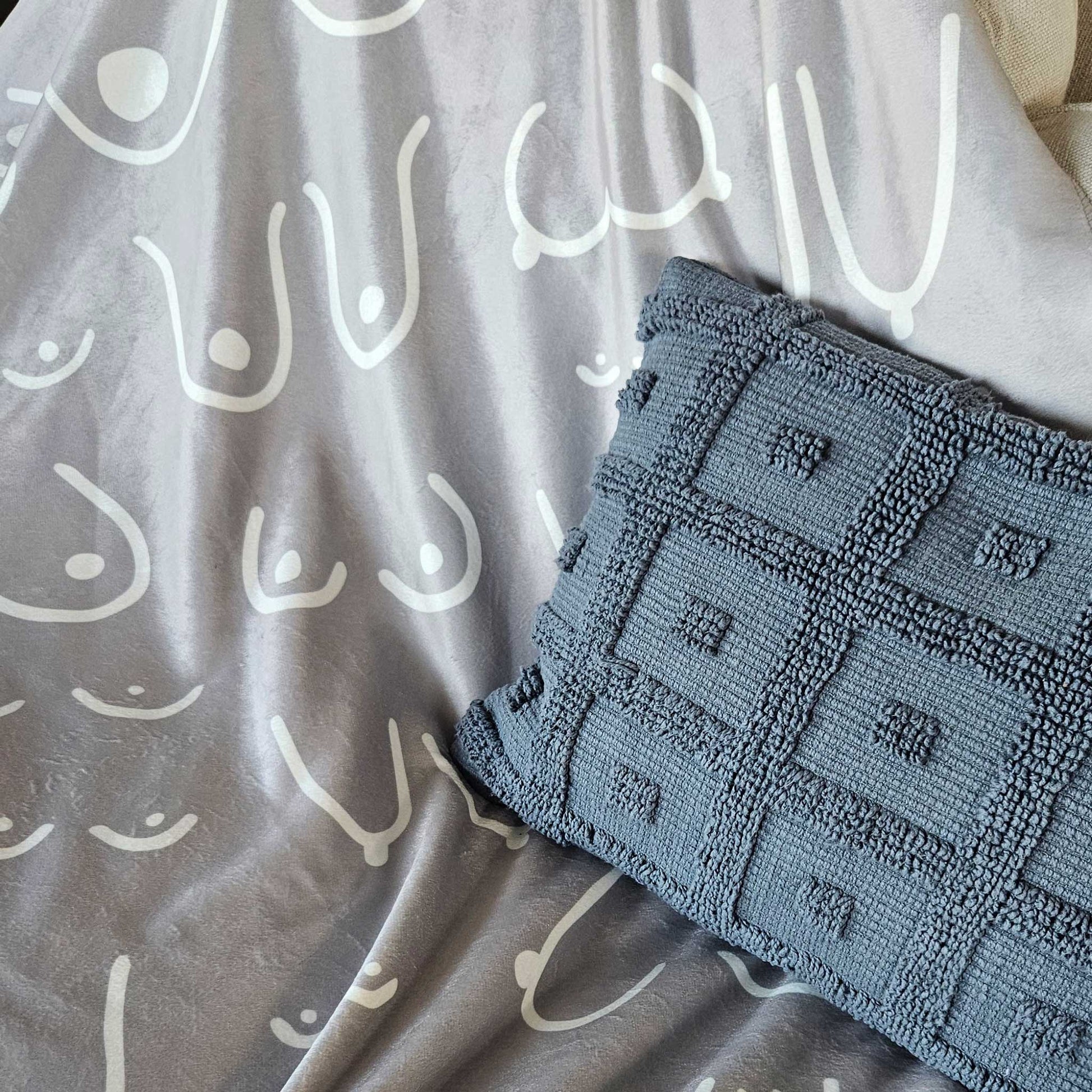 Textured blue fabric with geometric pattern on a gray background with white abstract designs