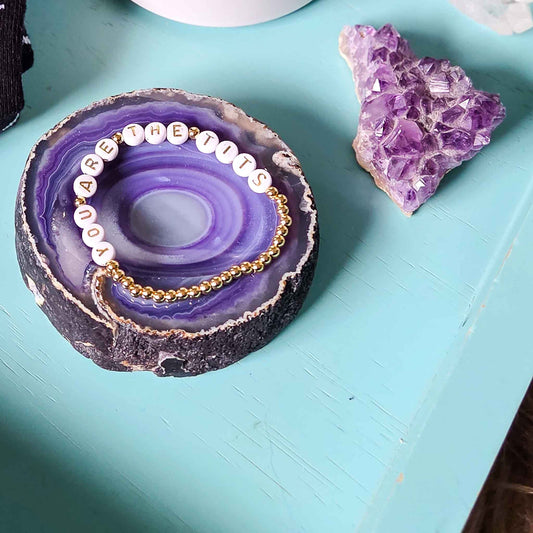 Jewelry set on a purple geode with a crystal on a teal surface