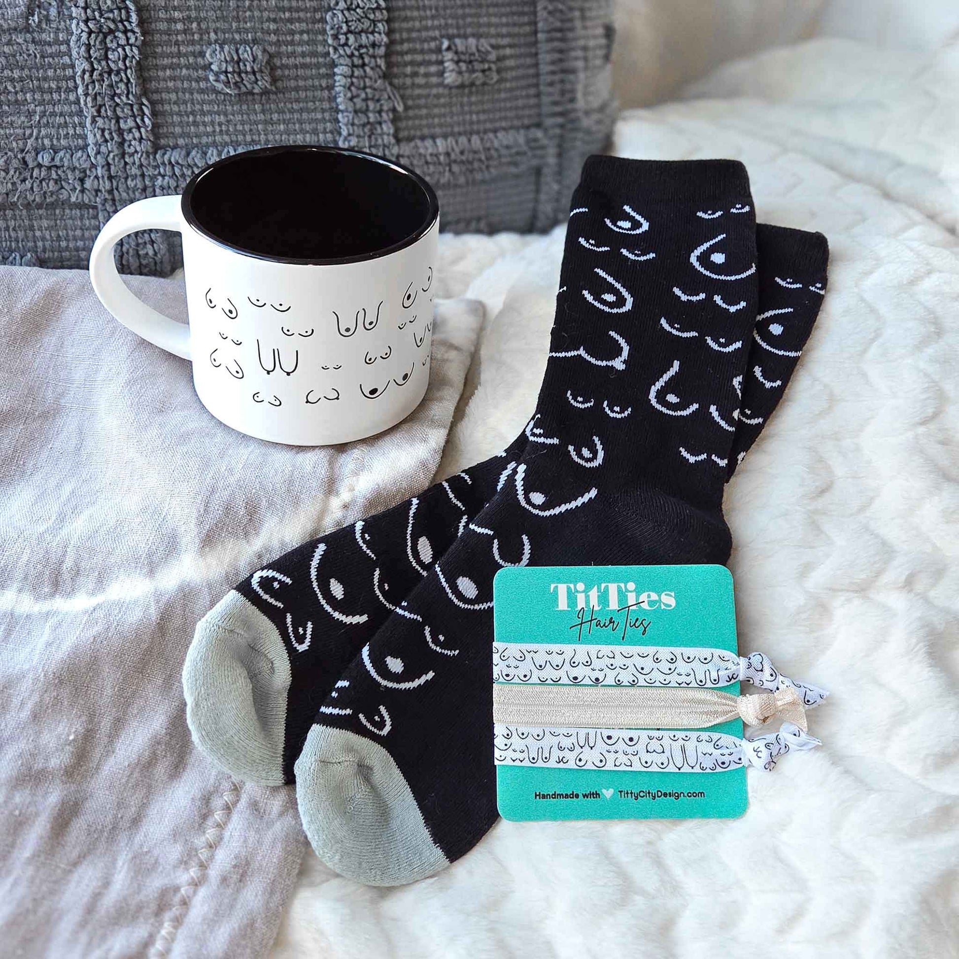 Black socks with white patterns and a mug on a bed