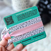 Card with hair tie designs and a QR code, held by a hand.