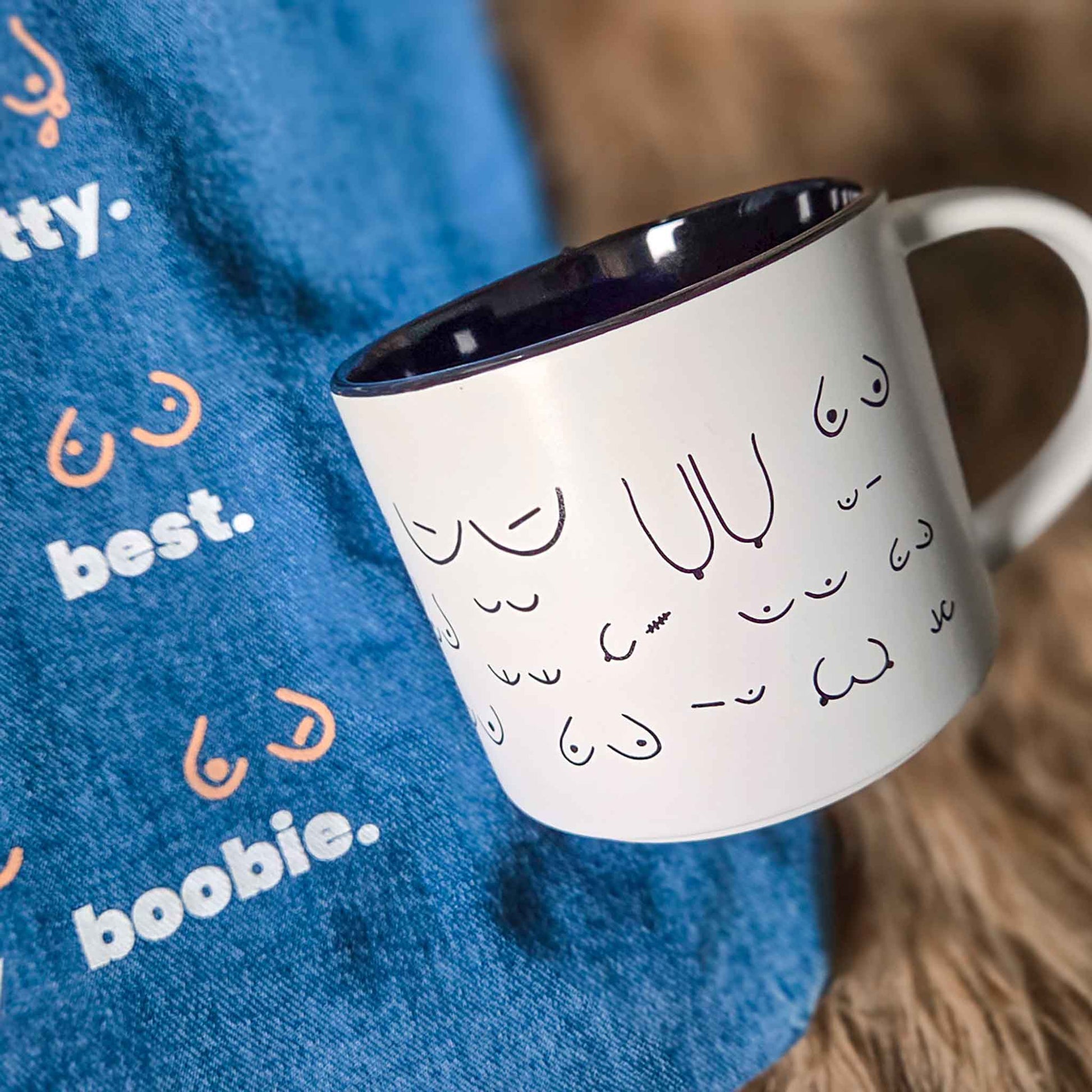 White mug with black interior and text on a blue fabric background