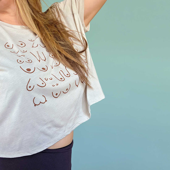 White t-shirt with design worn by a person against a light blue background