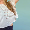 White t-shirt with design worn by a person against a light blue background