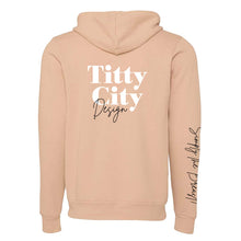 Load image into Gallery viewer, Titty City brand zip-up hooded sweatshirt in peach with logo on center back and slogan on right sleeve, back view
