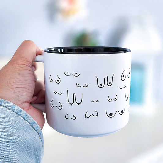 White mug with black interior held by a hand.