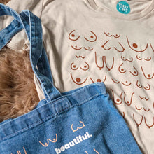 Load image into Gallery viewer, Blue denim tote bag with 'beautiful.' text on a beige shirt with red text.

